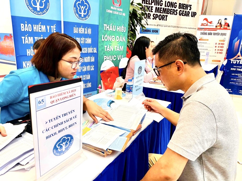 Lao động nam đang được giới thiệu, tư vấn về chính sách bảo hiểm xã hội. Ảnh: Nguyễn Hải.
