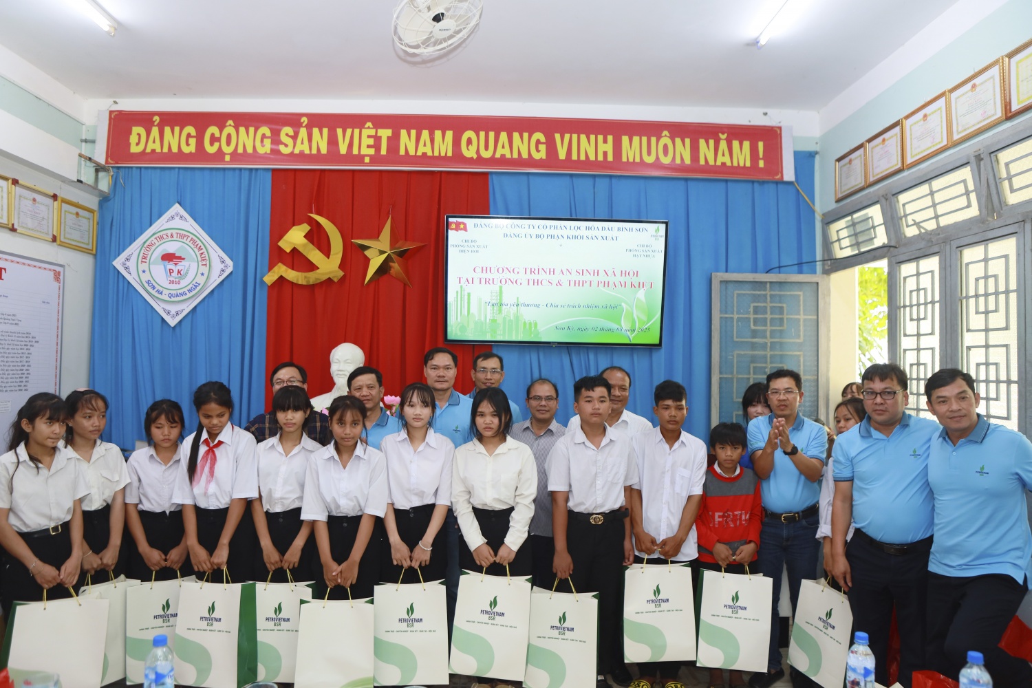 Đại diện Chi bộ Sản xuất Điện hơi và Sản xuất Hạt nhựa trao tặng các phần quà cho các em học sinh có hoàn cảnh khó khăn.