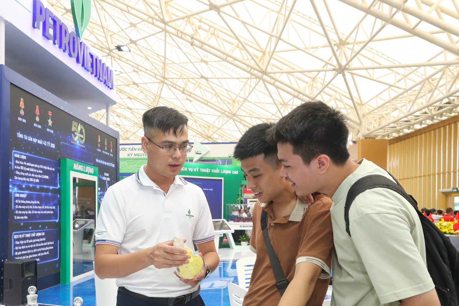 Em Nguyễn Trường Hiếu (giữa) - sinh viên năm tư Khoa Kỹ thuật Hóa học, Đại học Bách khoa Hà Nội tìm hiểu các sản phẩm tại gian hàng BSR.