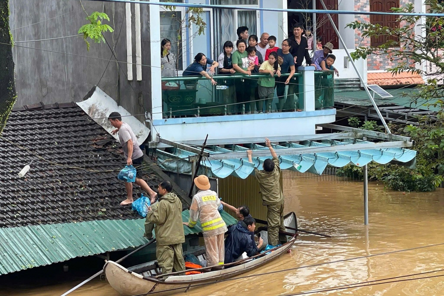 Người dân tại các vùng ngập lụt nhận đồ tiếp tế từ lực lượng chức năng.