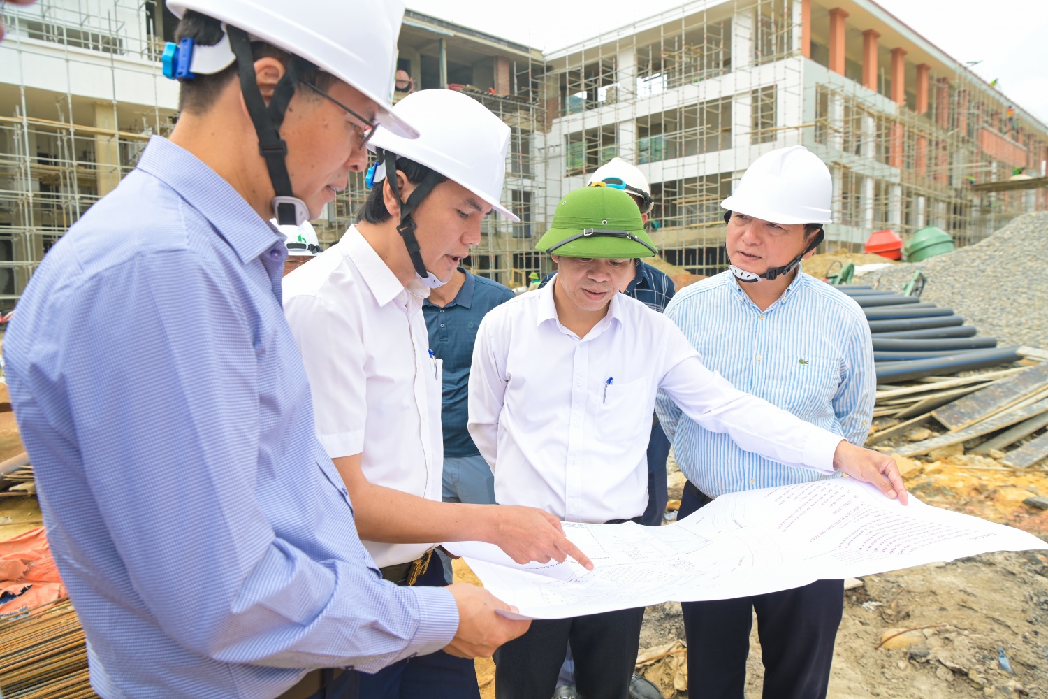 Đoàn nghe báo cáo về các hạng mục công trình và tiến độ hoàn thành dự án